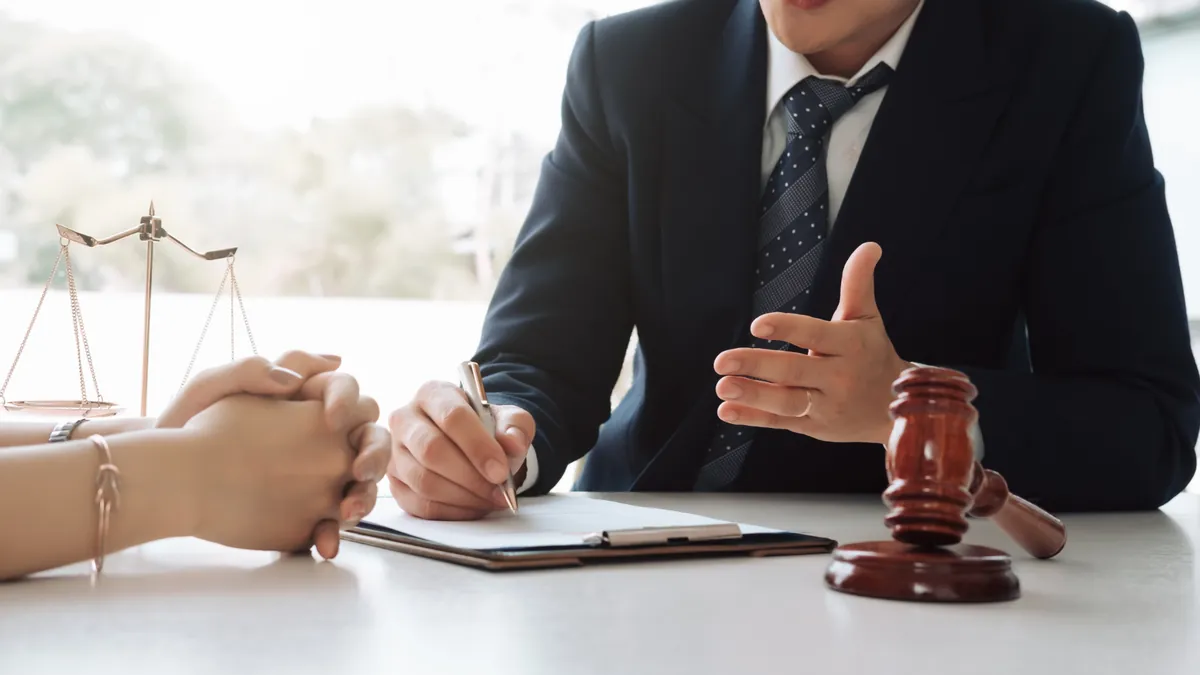 Consulta com advogado, com martelo e balança sobre a mesa